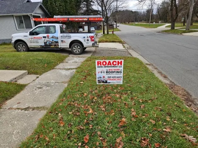 Roach Home Improvement truck and project sign at a job site